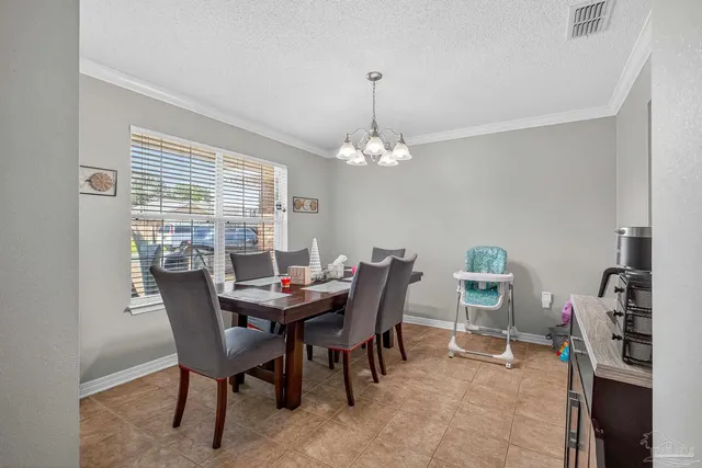 a view of a dining room with furniture and chandelier