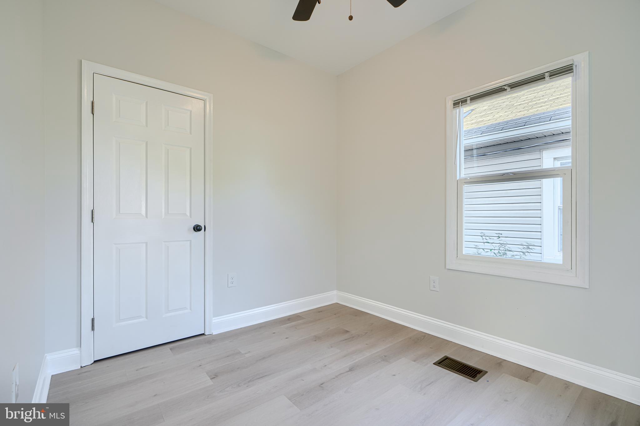 2126 Oakland Road Baltimore, MD 21220 - Photo 37 of 53 a view of an empty room with wooden floor and a window