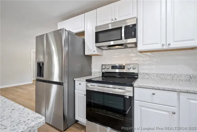 a kitchen with stainless steel appliances granite countertop a stove microwave and refrigerator