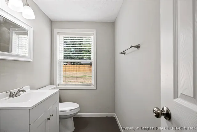 a bathroom with a sink toilet and window