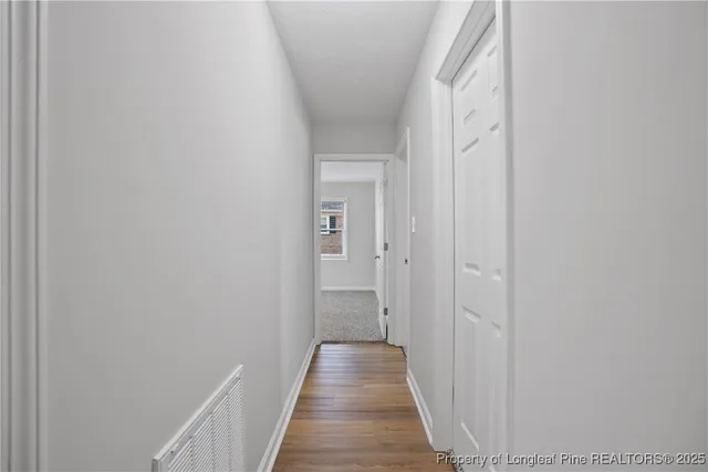 a view of a hallway with wooden floor