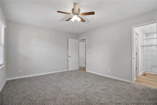 an empty room with closet and a chandelier fan