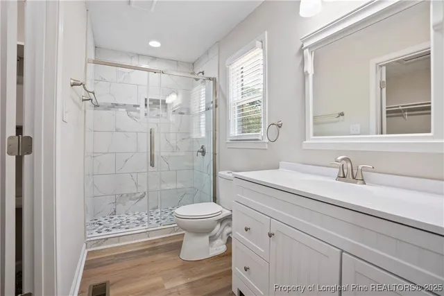 a bathroom with a granite countertop sink toilet a mirror a vanity and shower