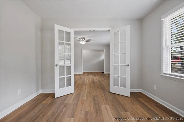 a view of empty room with wooden floor and window