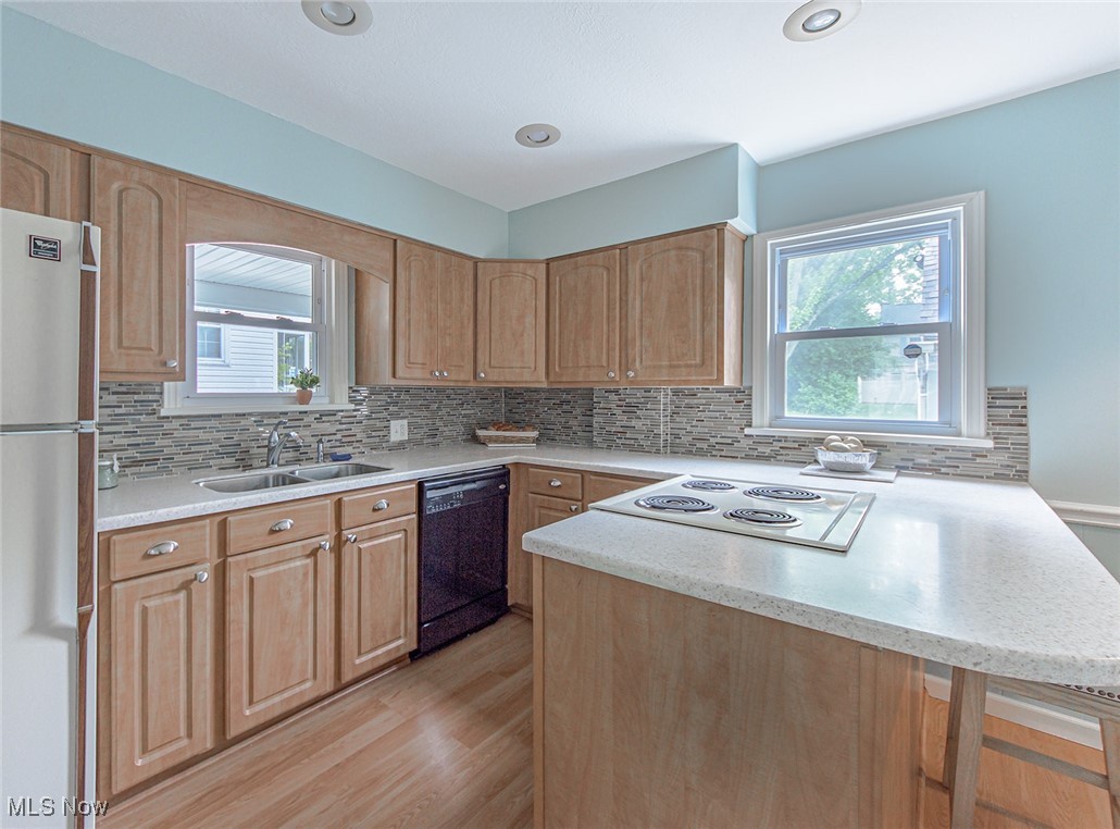 695 Ecton Road Akron, OH 44303 - Photo 8 of 26 Enter into the kitchen from the dining room. Notice the excellent work triangle. Kitchen cabinets have been updated, neutral corian counters, a glass tile backsplash, and the durable laminate flooring.