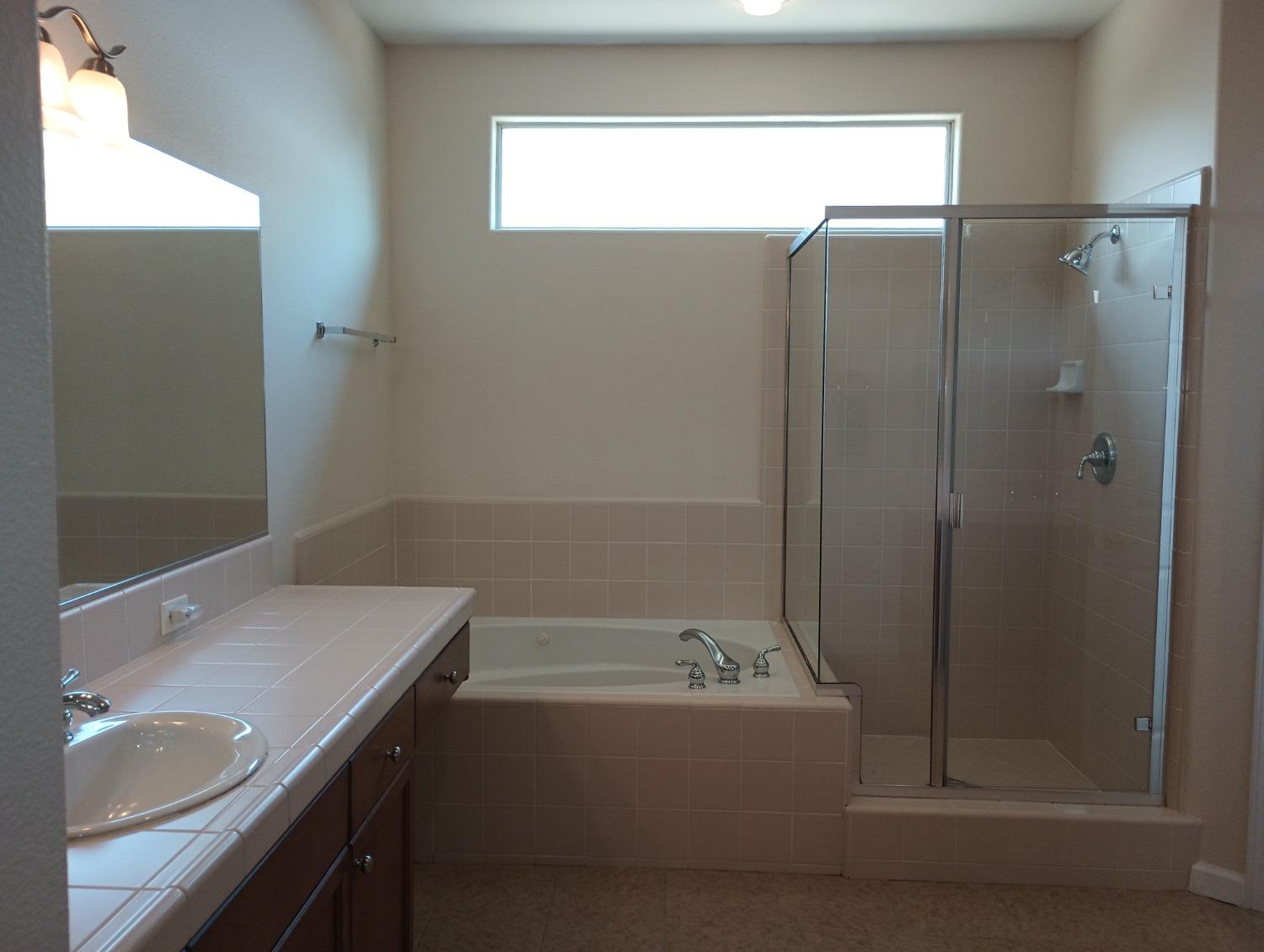 2979 Duncan Avenue Clovis, CA 93611 - Photo 17 of 27 a bathroom with a sink and mirror with bathtub