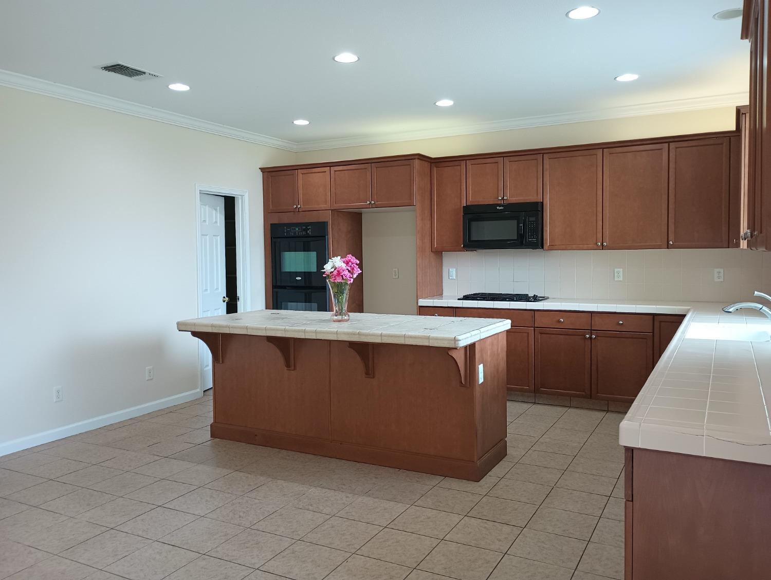 2979 Duncan Avenue Clovis, CA 93611 - Photo 8 of 27 a kitchen with stainless steel appliances a stove a microwave and a refrigerator