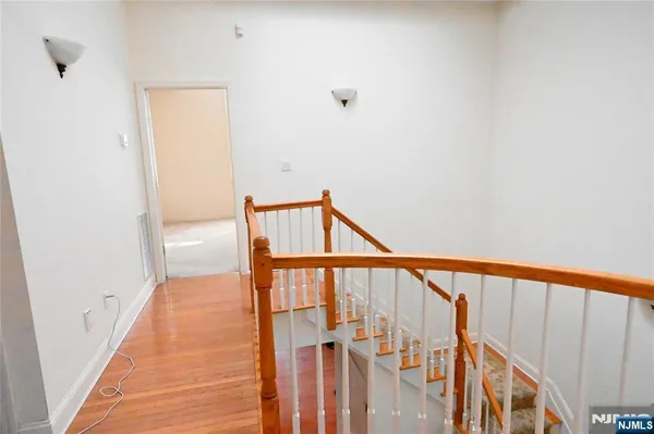 a view of staircase with railing and white walls