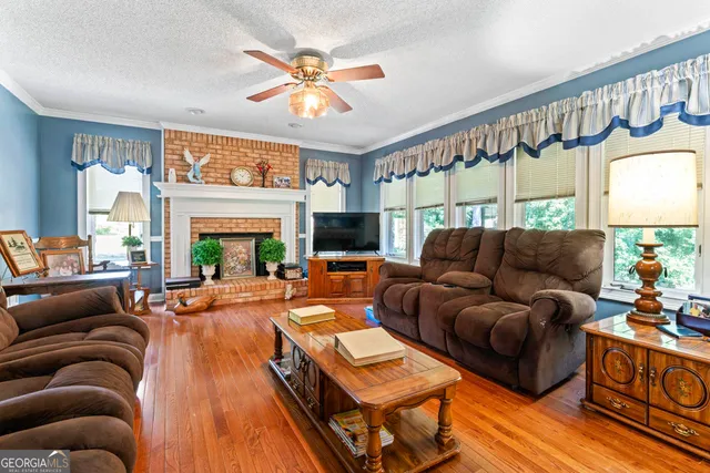 a living room with furniture a fireplace and a large window