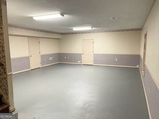 an empty room with cabinet and mirrors