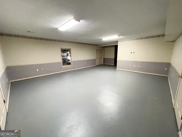 an empty room with a window and a ceiling fan