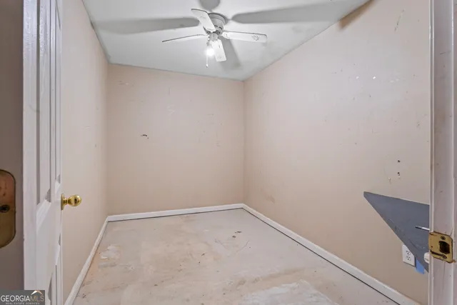 an empty room with a ceiling fan and carpet
