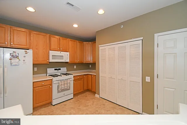 a kitchen with a refrigerator a stove top oven a sink and cabinets