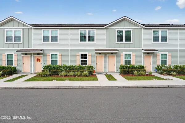 a front view of yellow house with a yard
