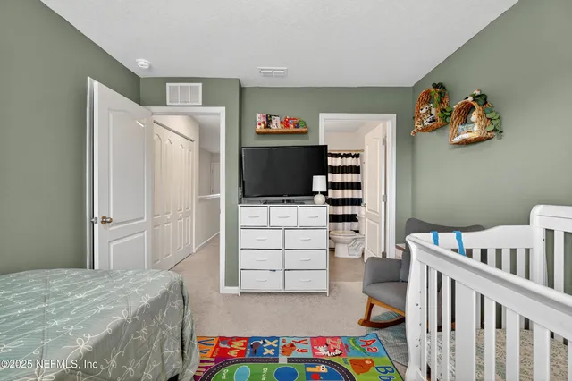 a bedroom with a bed and a refrigerator