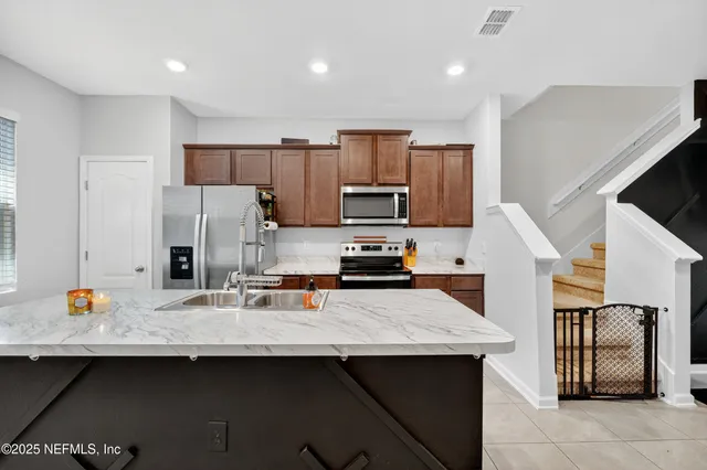 a kitchen with stainless steel appliances a sink counter space and cabinets