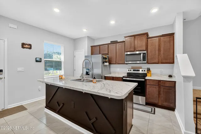 a kitchen with kitchen island granite countertop a sink counter top space appliances and cabinets