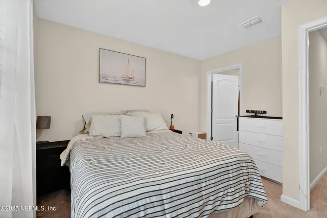 a bedroom with a bed and painting on the wall