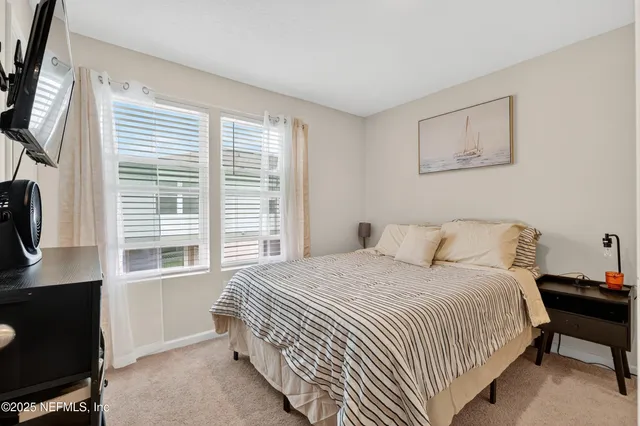 a bedroom with a bed a bookshelf and a window