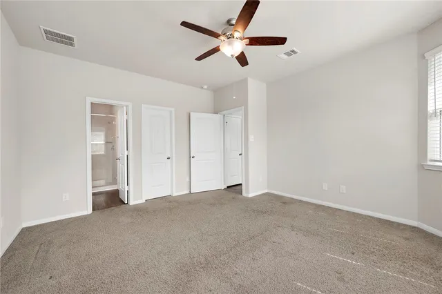 a view of an empty room with a ceiling fan