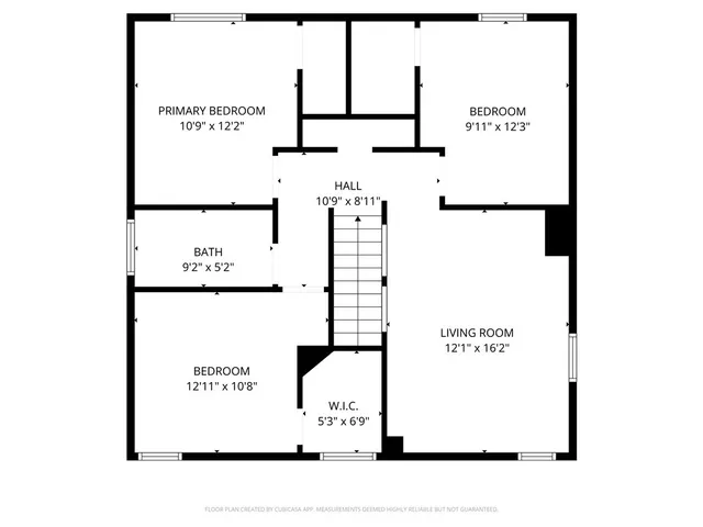 an empty room with wooden floor and a ceiling fan