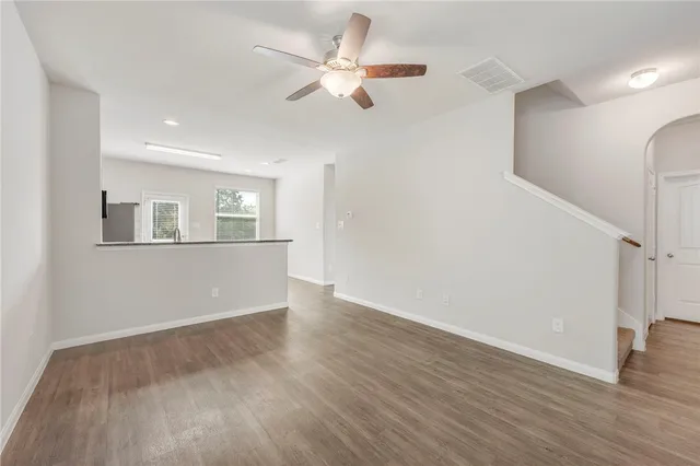 an empty room with windows and fan