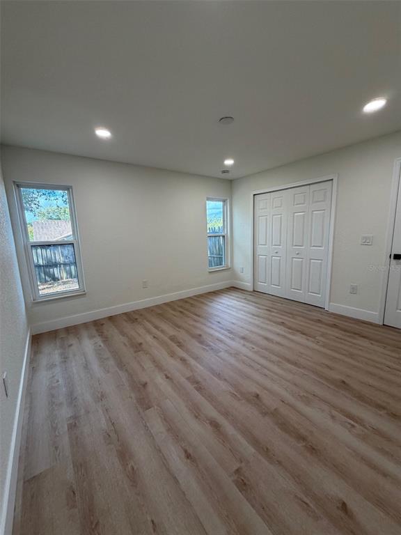 5342 Broken Pine Circle Orlando, FL 32818 - Photo 11 of 15 an empty room with wooden floor and windows