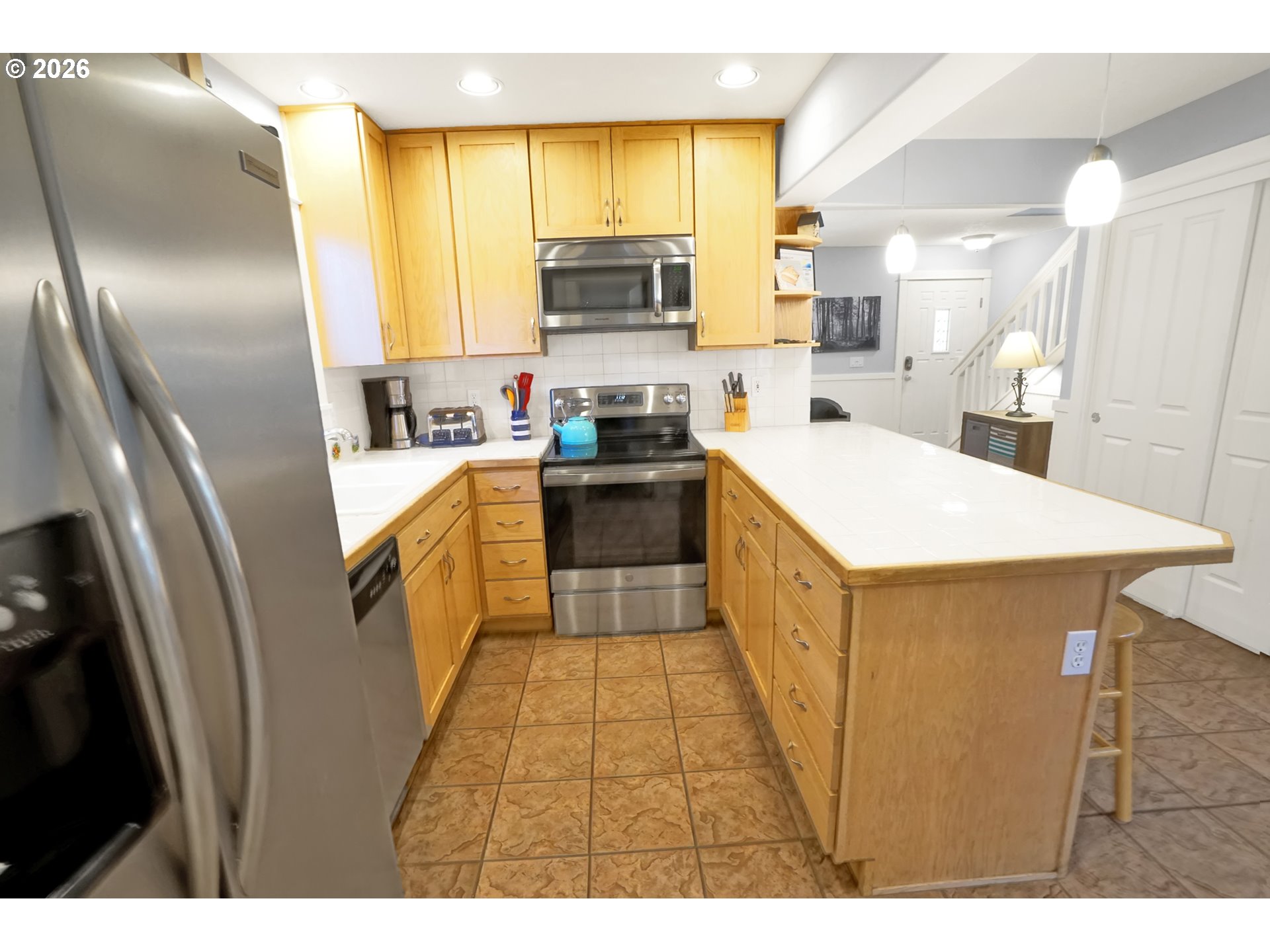 265 Bunchberry Way Depoe Bay, OR 97341 - Photo 11 of 48 a kitchen with stainless steel appliances a refrigerator a sink a stove a microwave a counter space and cabinets