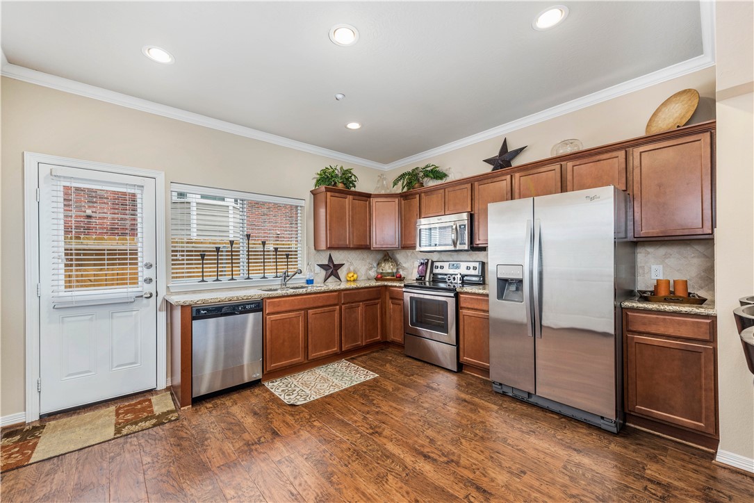 1198 Jones-Butler Road, Unit 1706 College Station, TX 77840 - Photo 4 of 15 a kitchen with granite countertop stainless steel appliances and wooden cabinets
