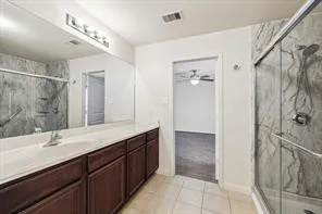 a bathroom with a double vanity sink mirror and shower