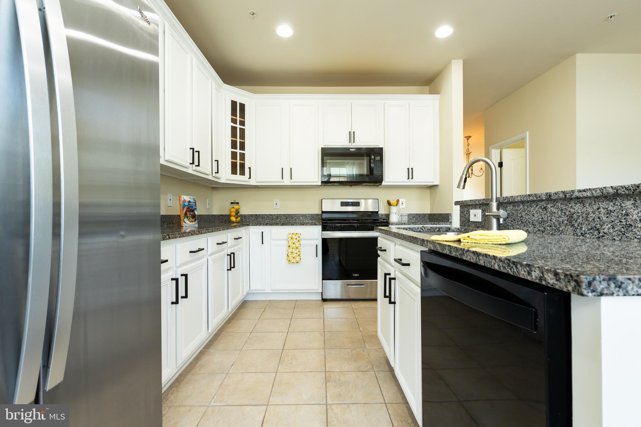637 Spectator Avenue Landover, MD 20785 - Photo 12 of 54 a kitchen with stainless steel appliances granite countertop a sink a stove top oven a refrigerator and dishwasher