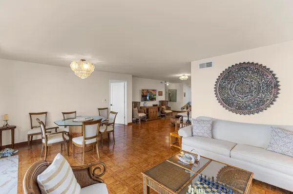a living room with furniture a rug and a dining table