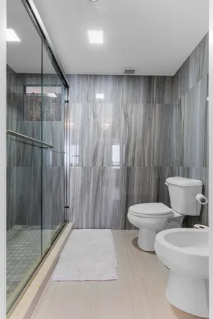 a bathroom with a toilet a sink and shower