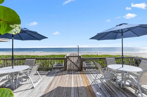 a view of deck with furniture and umbrella