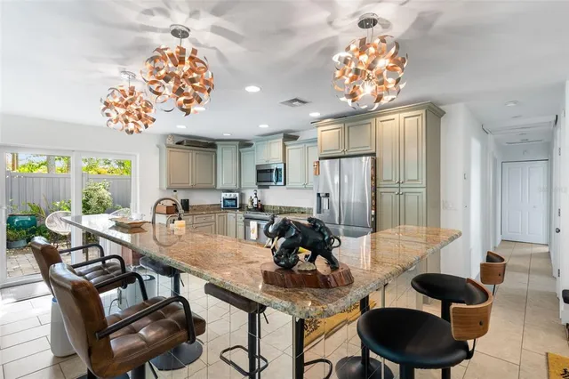 a large kitchen with stainless steel appliances granite countertop a sink stove and refrigerator