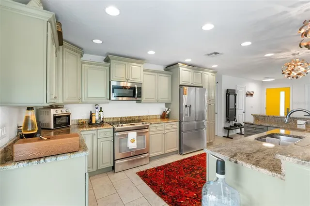 a kitchen with a stove a sink and a living room view