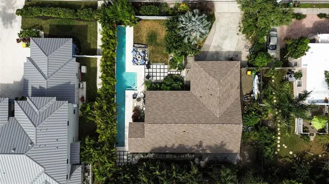 an aerial view of a house with a yard and large tree