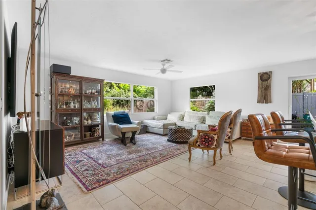 a living room with furniture a table and a large window