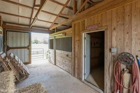 179 Ranchtown Road Elm Grove, LA 71051 - Photo 14 of 26 Interior barn space featuring natural wood paneling, exposed beam ceiling, a concrete floor, and two integrated stalls