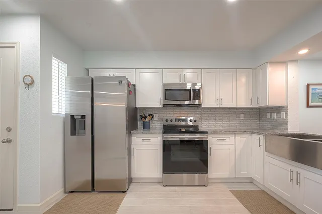 a kitchen with stainless steel appliances granite countertop a refrigerator stove and sink