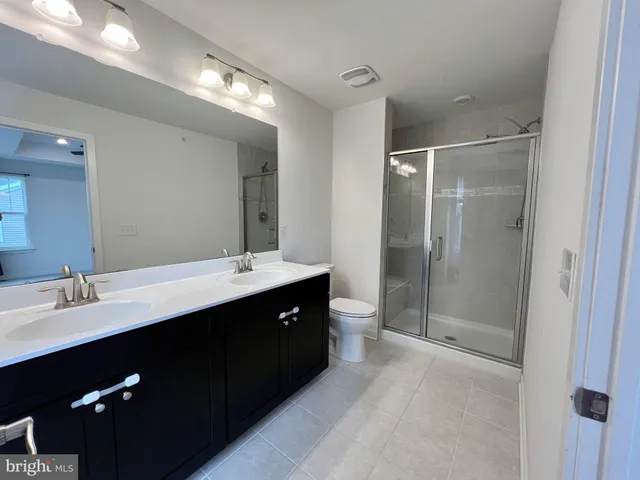 a bathroom with a double vanity sink mirror double shower and a mirror