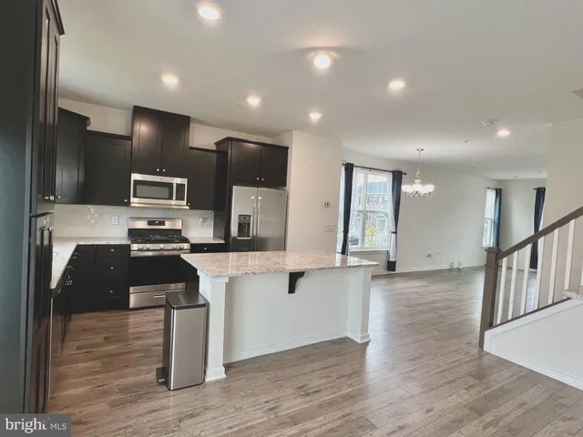 a kitchen with stainless steel appliances kitchen island granite countertop a stove a sink and a microwave