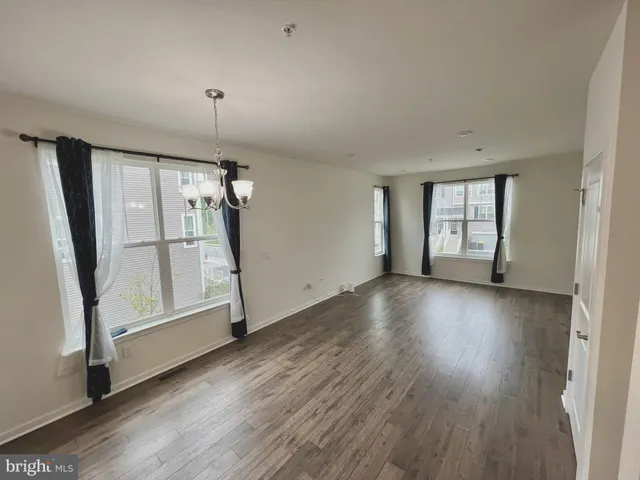 an empty room with wooden floor and a window