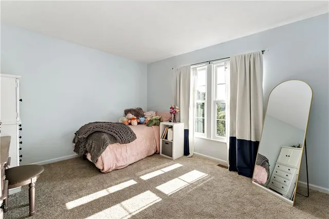 a bedroom with a bed and a large window