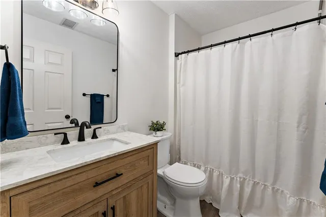 a bathroom with a double vanity sink toilet and a mirror