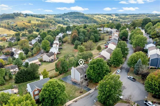 an aerial view of ocean and residential houses with outdoor space