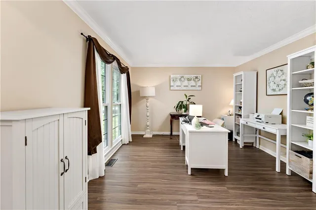a living room with furniture a large window and wooden floor