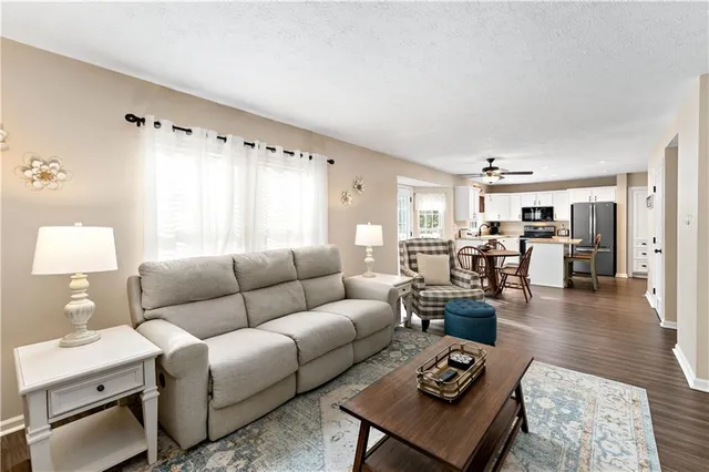 a living room with furniture and view of kitchen