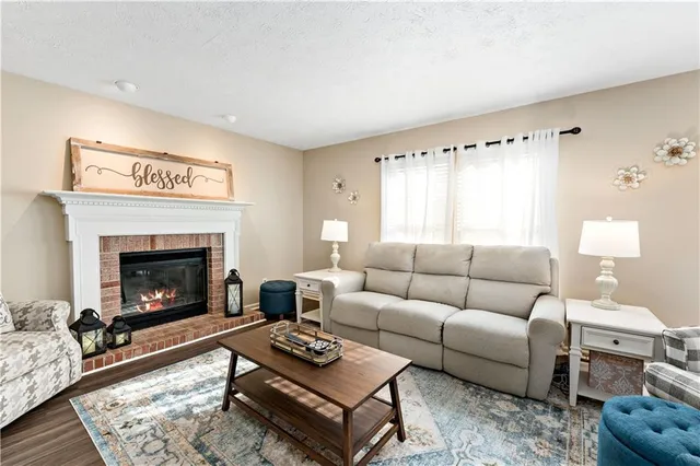 a living room with furniture a fireplace and window