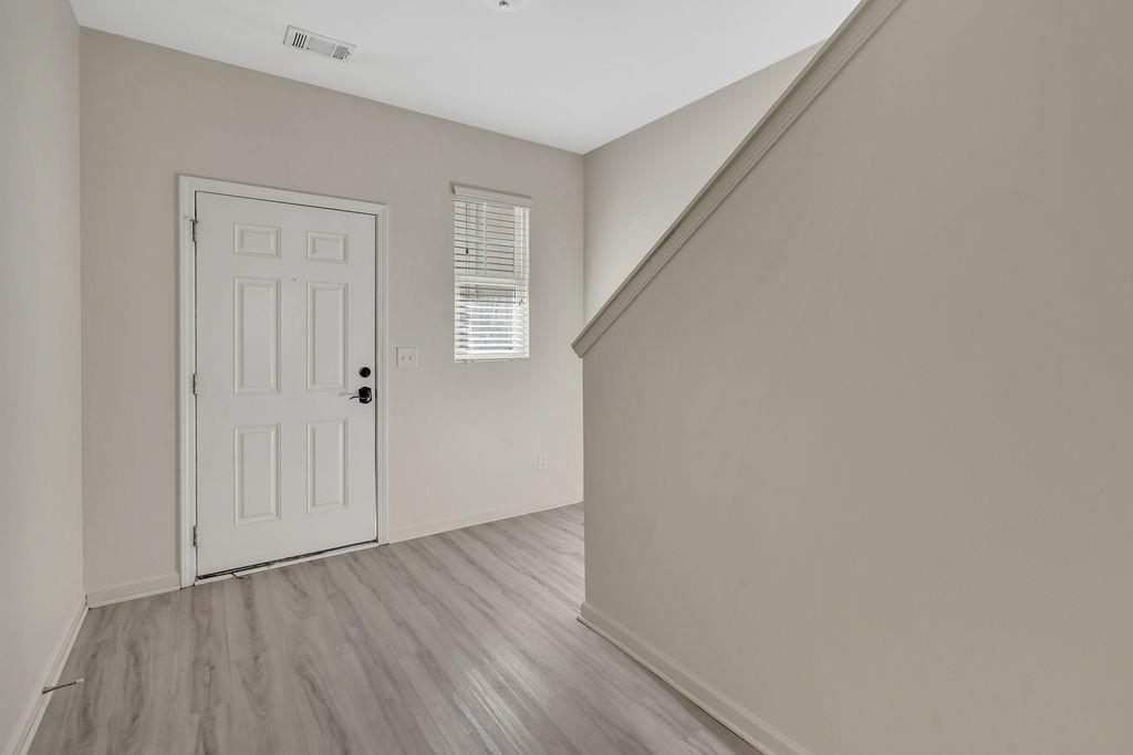 1938 Millstream Hollow Conyers, GA 30012 - Photo 3 of 16 a view of an empty room with wooden floor and a window